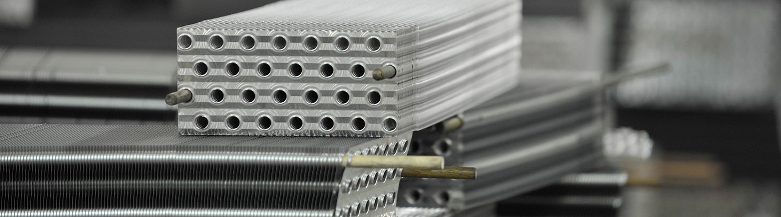 Precision-drilled tube sheets on stacked heat exchanger coils